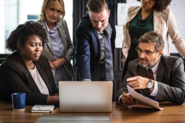 People in a meeting looking at data on a laptop