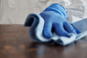 gloved hand wiping counter