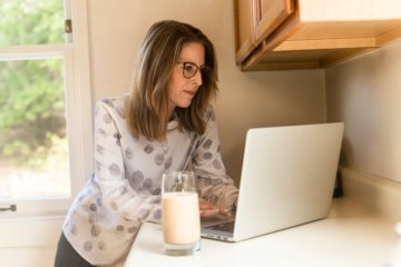 Woman working on laptop at tall counter