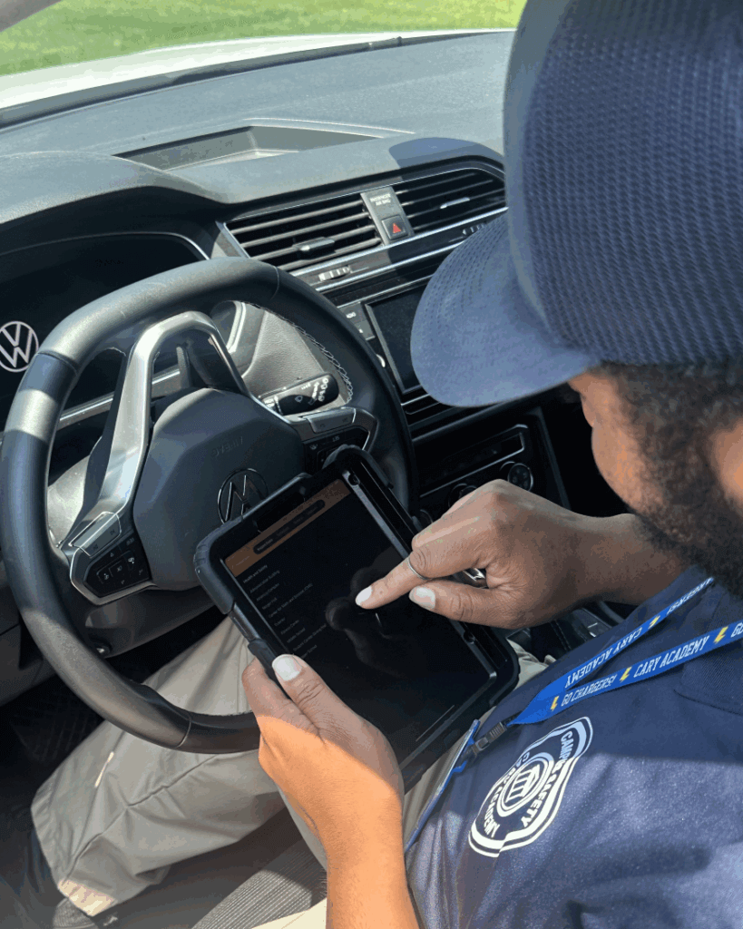 A campus safety professional for Cary Academy fills out an inspection on a tablet in his car.