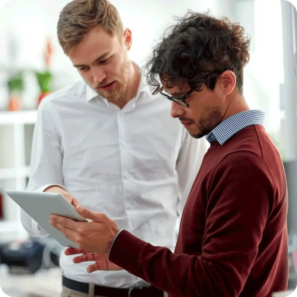 A photo of a contractor and a client discussing a janitorial PR report that captures the client’s feedback on the cleaning team’s service, referenced above.