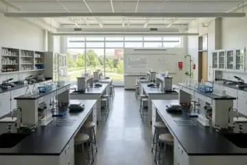 Clean, well-maintained science laboratory with empty workstations and research equipment.